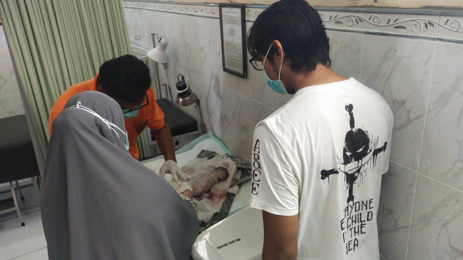 pihak kepolisian saat melakukan pemeriksaan pada bayi yang ditemukan. (madurakita.id/)